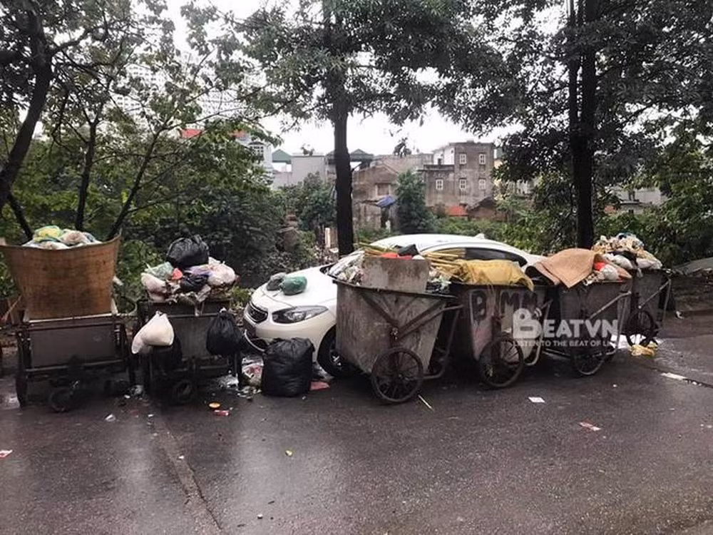 Hiện trường một chiếc ô tô màu trắng do đỗ vào vị trí bãi tập kết xe rác nên bị bao vây.