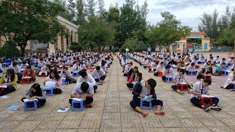 Mới đây, một trường THPT tại Thành phố Hồ Chí Minh đã áp dụng cách thức khá độc đáo khi cho các học sinh ngồi làm bài kiểm tra ngay giữa sân trường và mỗi người phải ngồi cách nhau ít nhất 1,5 mét.