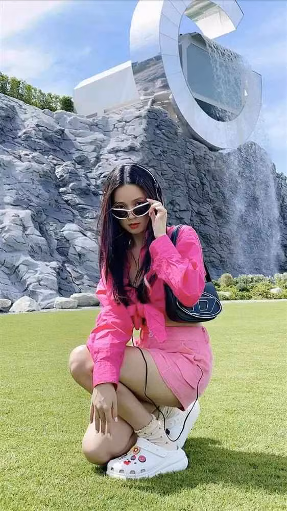 Khoảnh khắc ghi lại, cựu hot girl mặc chân váy ngắn phối cùng áo bra đen, phía ngoài còn khoác thêm chiếc sơ mi hồng cách điệu. Ngoài ra, loạt phụ kiện đi kèm như kính mắt, túi hiệu,... khiến nữ giảng viên càng thêm nổi bật.