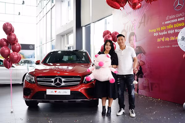 Vợ chồng trung vệ Bùi Tiến Dũng bên chiếc Mercedes-Benz màu đỏ.