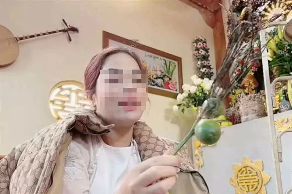 Cô đồng ngửi cau, sau đó bổ cau để xem bói cho khách (Ảnh: Cắt từ clip).