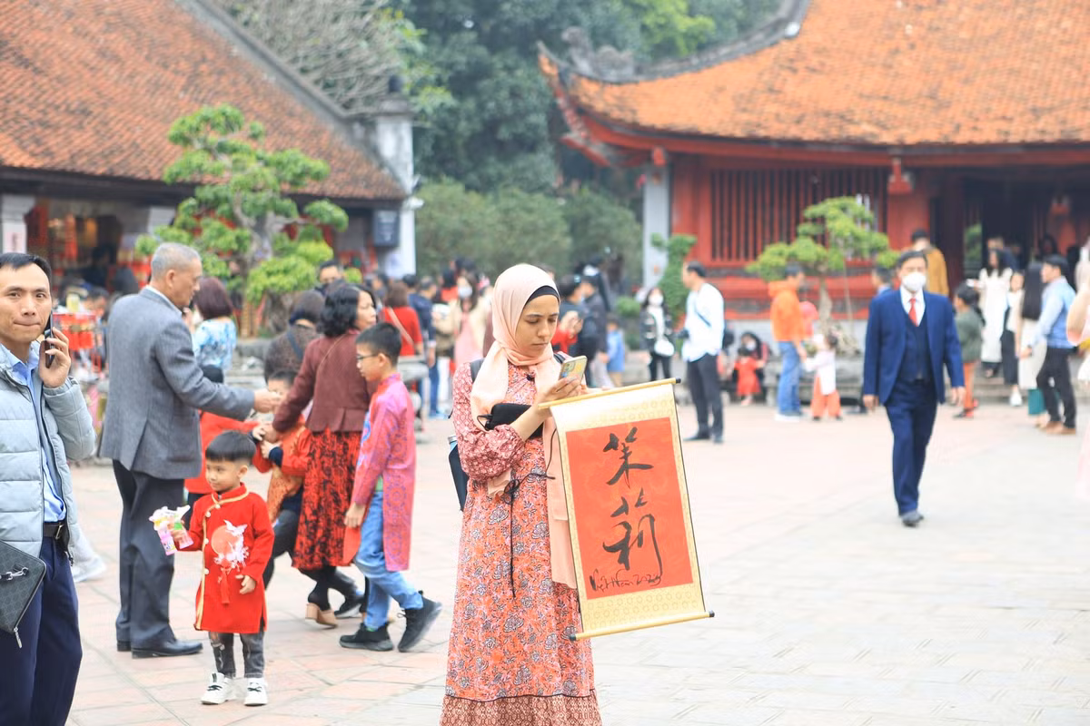 Một người bạn nước ngoài tới Văn Miếu vào đầu năm mới cũng xin chữ để về làm kỉ niệm du lịch Tết Nguyên Đán tại Việt Nam.
