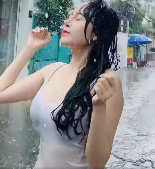 Trong đoạn video, hot girl bà Tưng mặc trang phục mỏng manh, thích thú khi tắm mưa. Cô viết: "Huyền Anh thích tắm mưa vô cùng luôn á. Đã gì đâu".