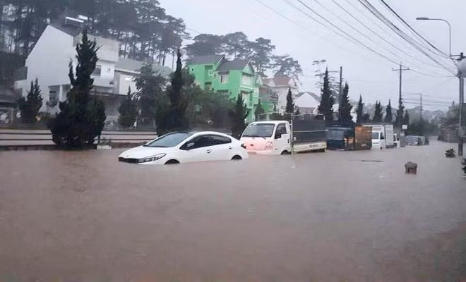 Bên ngoài đường lớn tại Đà Lạt, một số người phải vật lộn với xe chết máy, phải dẫn bộ cả đoạn dài. Ô tô cũng không khá hơn khi nước cũng đã ngập đến gần một nửa.