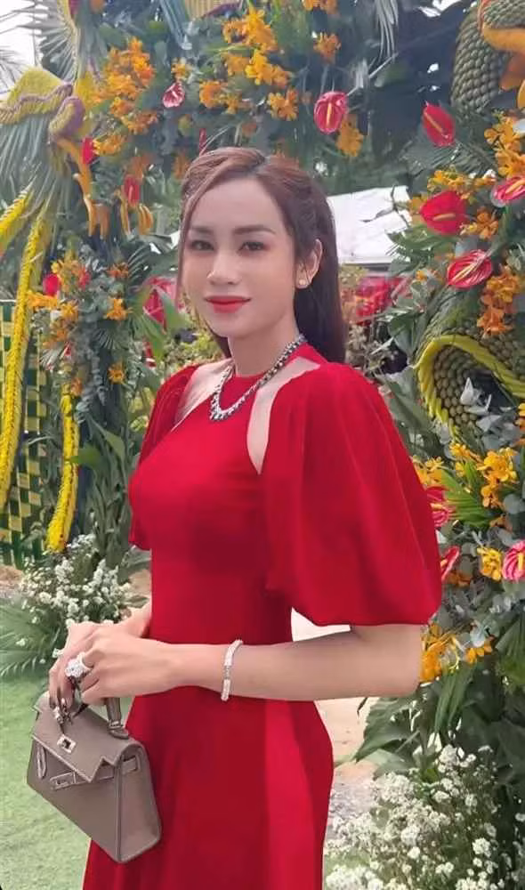 Lương Mỹ Kỳ diện chiếc áo dài cách tân cut-out màu đỏ nổi bật, kết hợp túi Hermès đắt đỏ cùng hàng loạt trang sức từ vòng cổ, vòng tay đến nhẫn.
