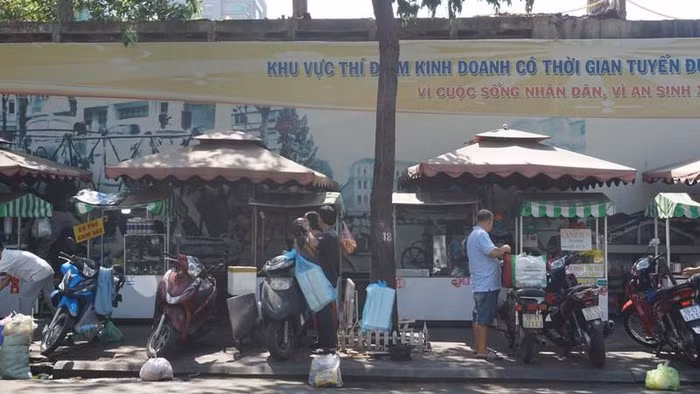 “Tôi ủng hộ mô hình này, dù đã triển khai hơn hai năm nhưng rất hiệu quả. Tôi nghĩ TP nên triển khai thêm ở nhiều tuyến đường khác, điển hình như khu vực Công viên Gia Định” - anh Vinh nói. (Một số hộ dân đang tất bật dọn hàng ra bán vào sáng sớm)