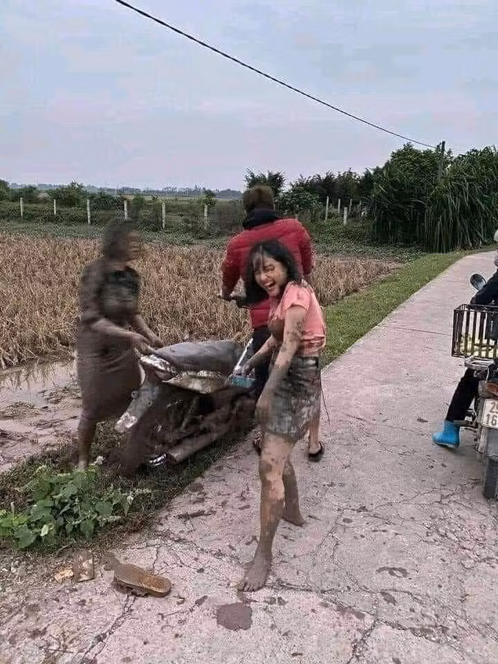 Hai cô được một thanh niên dựng xe lên giúp. Dĩ nhiên chiếc xe cũng không tránh được cảnh nhuốm đầy bùn như 2 khổ chủ.