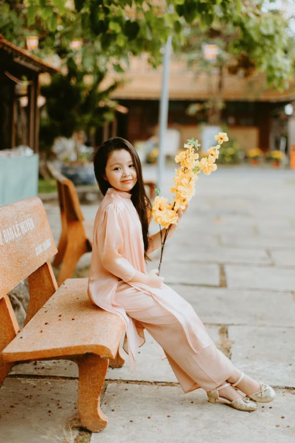 Cadie Mộc Trà còn được bà ngoại cho diện một bộ đầm hoa nữ tính, kết hợp với túi xách cùng màu.