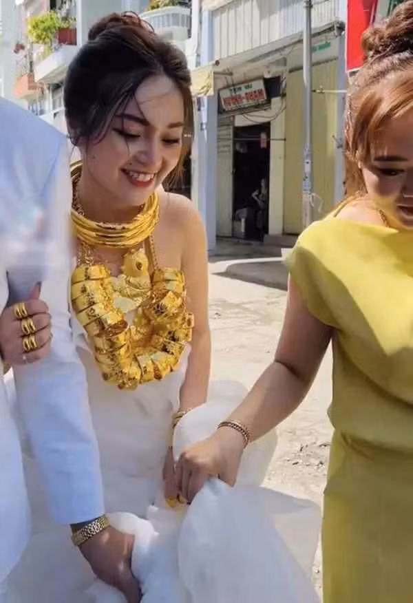 Khoảnh khắc do TikTok T.F chia sẻ lại cho thấy, cô dâu miền Tây được người thân đeo cho rất nhiều kiềng vàng, nhẫn, và đặc biệt là chiếc dây chuyền xâu vô số lắc tay.