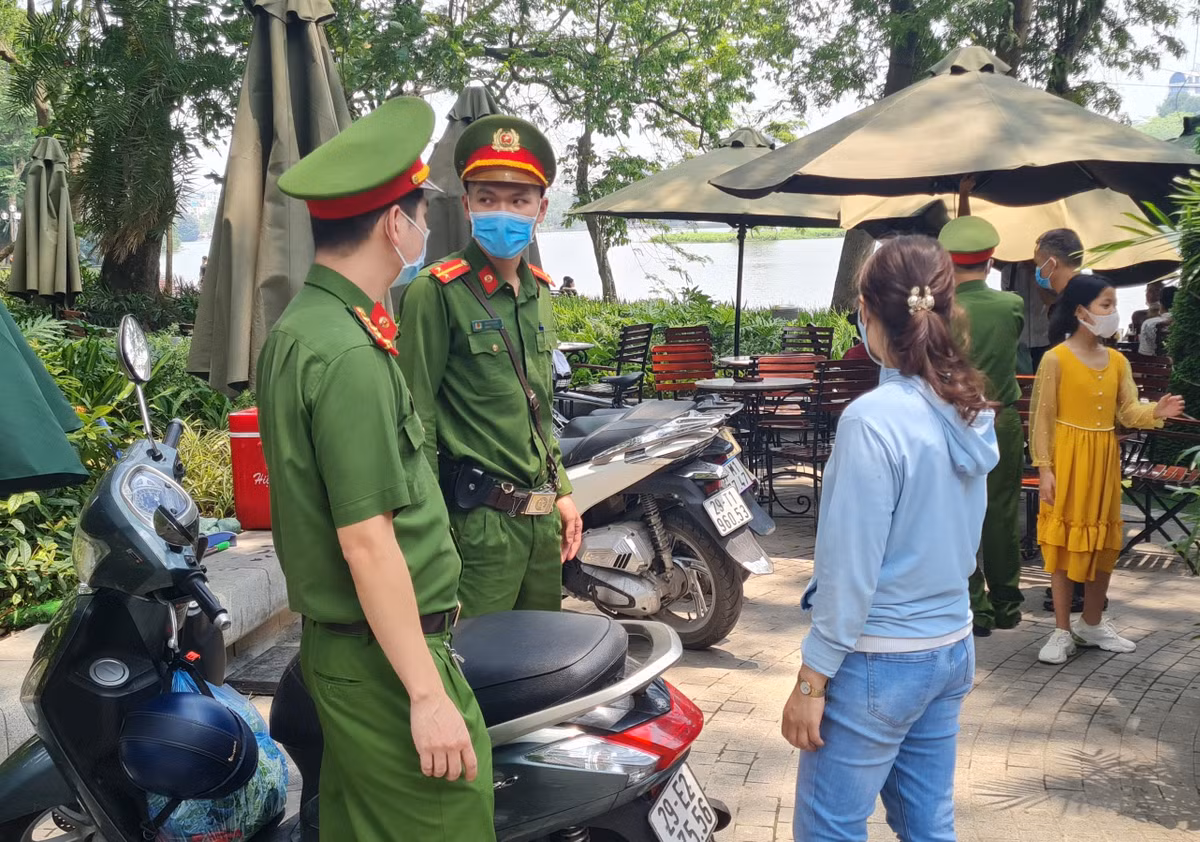Công an Quận Hoàn Kiếm nhấc nhở chủ quán cafe và khách nâng cao tinh thần phòng chống dịch.
