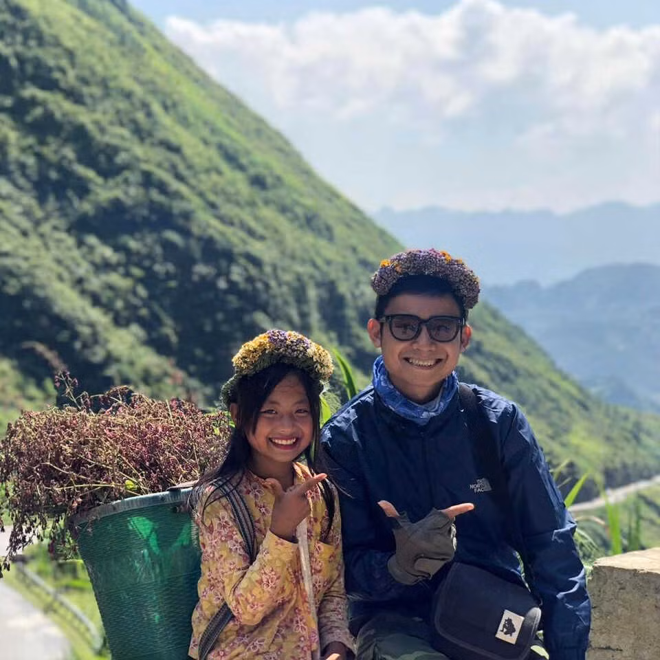 Khi đó, Dua đang mời chào khách du lịch mua những chiếc vòng hoa rừng do em và các bạn tự đi hái. Khoác trên người bộ đồ dân tộc đặc trưng, mái tóc buộc nửa đầu buông xõa, cô bé đã chinh phục bất kì người xem clip nào bởi vẻ ngoài xinh xắn, nụ cười rạng rỡ và nhất là đôi mắt có màu rất đặc biệt.