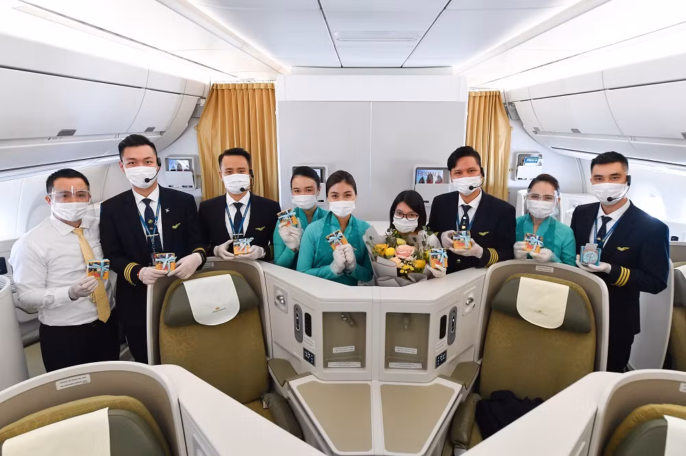 Đại diện tổ phi công thay mặt chuyến bay tặng quà cho đại diện một khách hàng nữ.