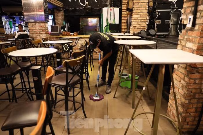 Nhân viên nhà hàng tranh thủ lau dọn quán trước ki đóng cửa..