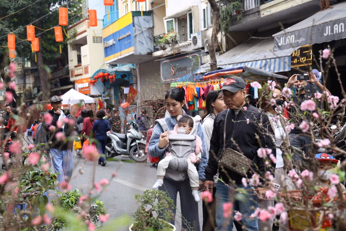 Một gia đình tranh thủ ngày Hà Nội tạnh ráo để đi ngắm hoa tại chợ hoa Hàng Lược.