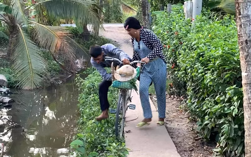 Đi được một đoạn, anh chồng lại nhảy xuống đi bộ, lôi “nóc nhà” xềnh xệch phía sau. Hứng chí lên lại nhảy lên lưng, bắt vợ cõng.