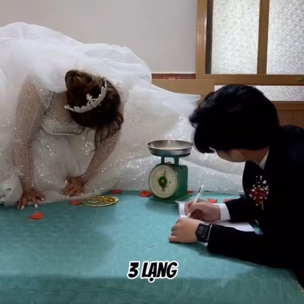 Chú rể thì có nhiệm vụ lấy giấy và bút ra ghi rõ số lượng vàng mà cô dâu cân được, còn về phía cô dâu, cô liên tục đọc rõ số vàng do ai tặng, bao nhiêu cân, từ mẹ chồng, mẹ vợ, anh em trong nhà, họ hàng,... đều được kiểm kê rõ ràng.