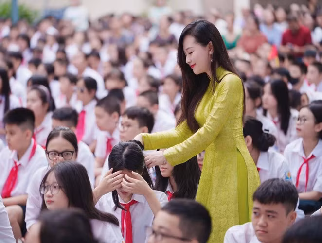 Hình ảnh lan truyền trên mạng được chụp vào sáng 5/9 trong buổi lễ khai giảng của nhà trường. Nữ giáo viên cho biết, khai giảng là một ngày lễ lớn, ngày hội toàn dân đưa trẻ đến trường nên mỗi giáo viên đều có sự chuẩn bị chu đáo, ăn mặc chỉn chu, lịch sự.