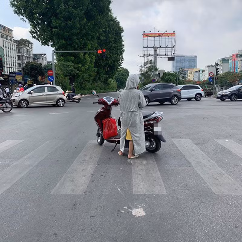 Hình ảnh người phụ nữ dừng đèn đỏ chẳng giống ai, trơ trọi giữa hai bên đường không một bóng xe cộ khiến nhiều người ngao ngán.