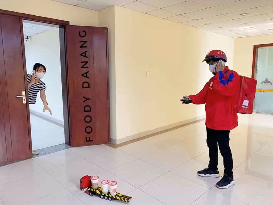 Khi tới địa chỉ của khách hàng, chàng shipper cẩn thận đặt đồ uống lên trên chiếc xe đồ chơi và điều khiển nó di chuyển tới đúng vị trí mà khách đang chờ sẵn.