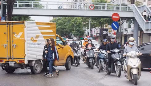 Bỏ qua sự tồn tại của cầu bộ hành, người đi bộ vẫn thản nhiên di chuyển dưới lòng đường. (Ảnh chụp tại phố Chùa Bộc, đoạn qua Học viện Ngân hàng). Ảnh: CT.