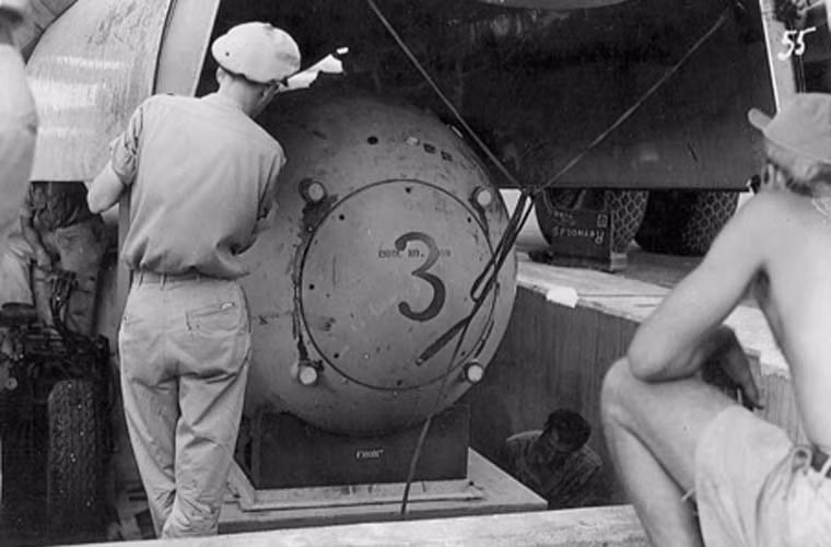 Bom nguyên tử Fat Man đang được đưa vào khoang bom máy bay B-29 mang tên "Block's Car" do thiếu tá Charles Sweeny điều khiển. Quả bom có sức công phá lớn hơn so với Little Boy, 21 kiloton tương đương 21.000 tấn TNT.