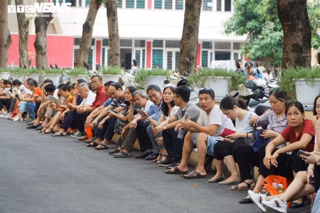 Phụ huynh vừa ngồi đợi con vừa tranh thủ trao đổi với nhau để giảm bớt căng thẳng.