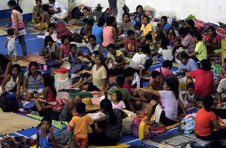 Người dân từ các ngôi làng ven biển tá túc tại một trung tâm tránh bão ở Alcala khi bão Haima đổ bộ Philippines. Chính quyền địa phương Philippines đã tiến hành sơ tán khẩn cấp hơn 90.000 người dân trong đợt bão Haima.