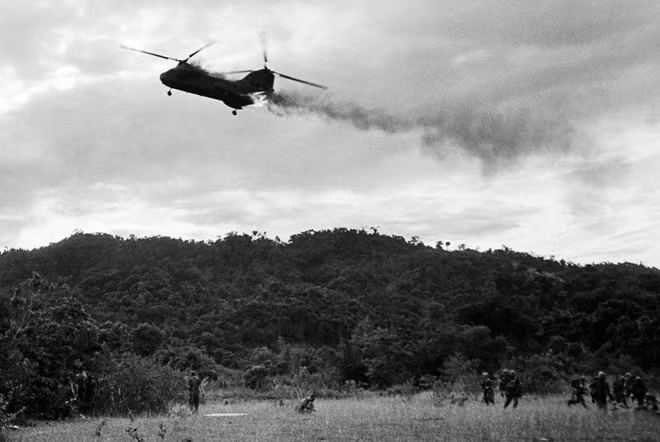 Trực thăng vận tải đa nhiệm CH-46 Sea Knight của Thủy quân lục chiến Mỹ bị trúng đạn và bốc cháy ở ranh giới chia cắt hai miền Bắc – Nam của Việt Nam năm 1966. Nó lao xuống một ngọn đồi, khiến 13 người thiệt mạng và 3 người bị bỏng nặng. Ảnh: AP.