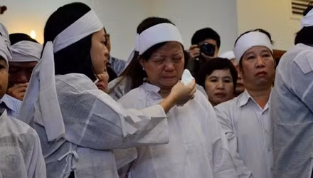 Con gái ông Nguyễn Bá Thanh lau nước mắt cho mẹ trong giờ truy điệu sáng 16/2.