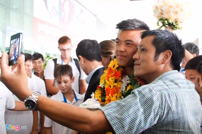 Một hành khách có mặt tại sân bay Tân Sơn Nhất xin chụp ảnh lưu niệm cùng tay vợt đầu tiên của Việt Nam giành chức vô địch Wimbledon trẻ.