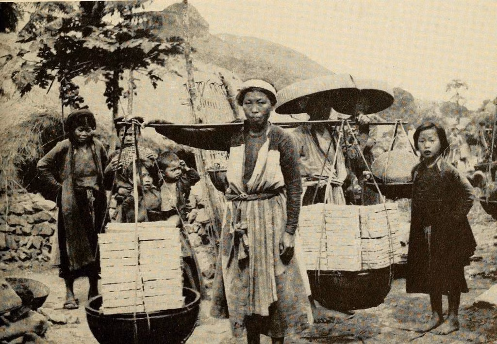 Một phụ nữ gánh vàng mã ra chợ ở làng Đông Sơn, Thanh Hóa. Ảnh: The People of French Indochina.