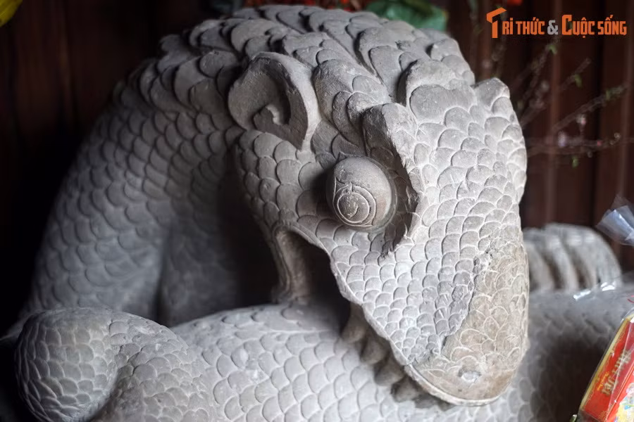 Tượng được làm bằng đá sa thạch, có niên đại từ thời Lý (khoảng thế kỷ 12), có hình một sinh vật nửa rồng nửa rắn có thân cuộn vào nhau, phần đầu vươn lên uốn cong rồi cúi xuống ngoạm vào phần thân phía trên. Chân rồng có móng vuốt nhọn, xòe rộng, bấu chặt vào phần.