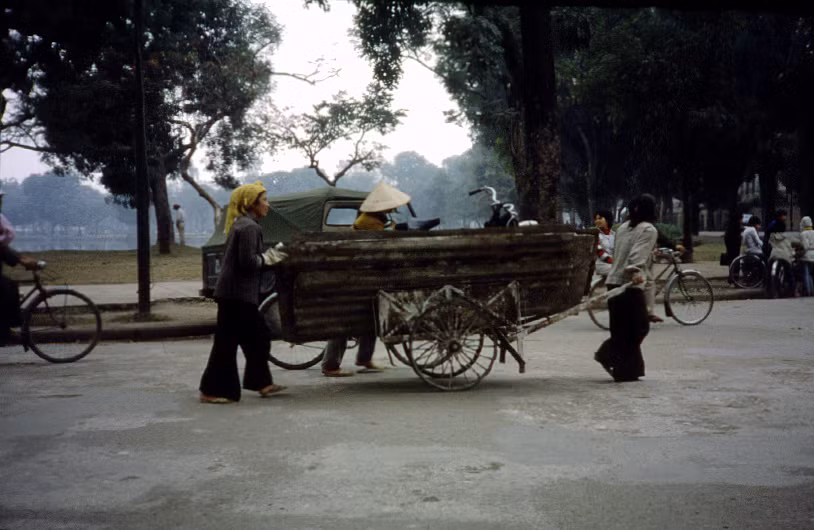 Chiếc xe kéo chở mái tôn cũ đi qua bờ hồ Thiền Quang.