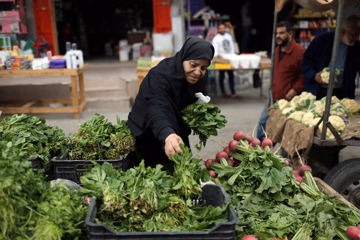 Người phụ nữ Palestine bán rau xanh trong một khu chợ ở phía nam Dải Gaza.