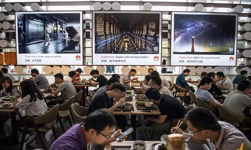Nhân viên Huawei ăn trưa tại cơ sở Bantian ở Thâm Quyến. Mọi nhu cầu của họ được đáp ứng trong đại bản doanh của Huawei: nhà ở giá rẻ, quán cà phê, phòng tập, khách sạn, phương tiện công cộng, và tàu điện nhập khẩu từ Thụy Sĩ. Ảnh: Getty Images.
