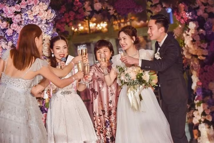 Cô dâu chú rể vui mừng nâng ly cùng gia đình, bạn bè thân thiết.