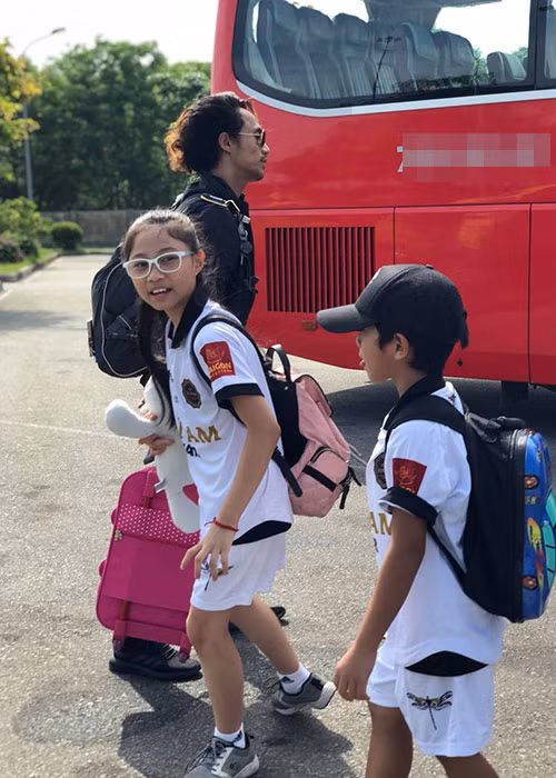 Hình ảnh Phạm Anh Khoa kéo vai li bên con gái Cào Cào và con trai Châu Chấu.