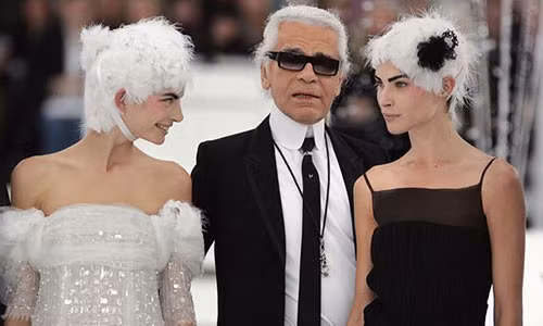 Ông cùng hai người mẫu chào khán giả khép lại show diễn Xuân - Hè đầy thành công của Chanel vào năm 2005.