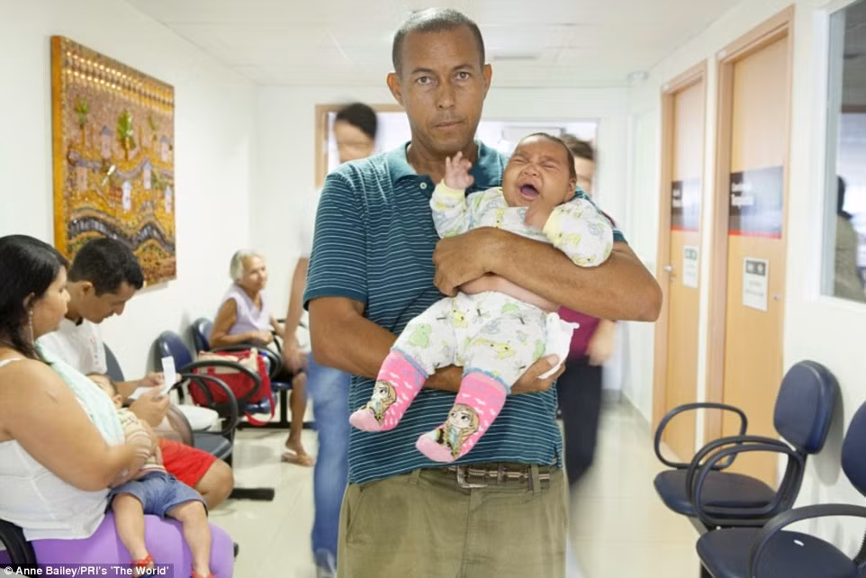 Paulo Rogerio Cavalcanti Araújo, 47 tuổi bế con gái 4 tháng tuổi Eduarda Vitória trong vòng tay.