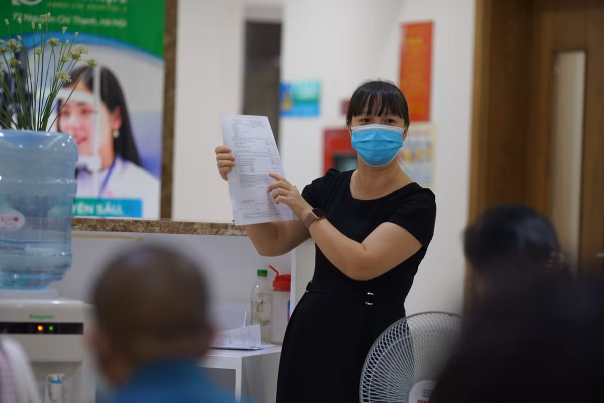 Trong lúc ngồi tại phòng chờ, Ban tổ chức tiêm đã bố trí cán bộ hướng dẫn, lưu ý người dân điền đầy đủ thông tin vào phiếu đăng ký tiêm.