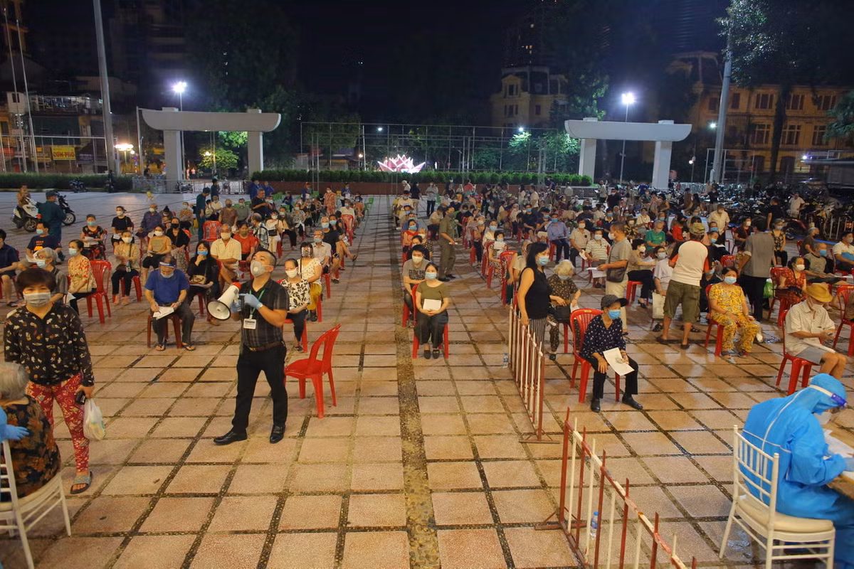 Nguoi dan Ha Noi di tiem vac xin trong toi muon