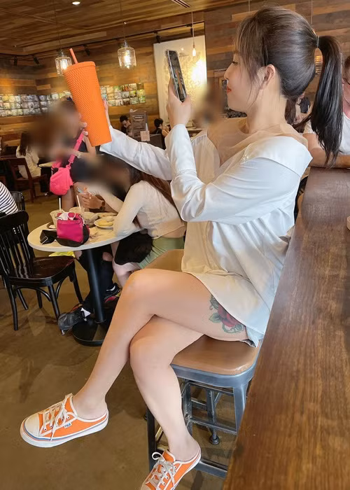Nữ MC diện mốt giấu quần, để lộ hình xăm khi ngồi.