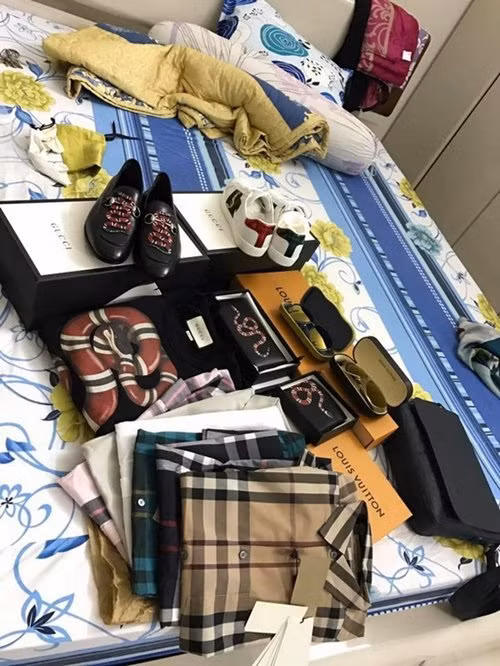 Các phụ kiện như giày, áo...đến từ thương hiệu Gucci và Louis Vuitton trải đầy giường. Ảnh: Dân Việt.