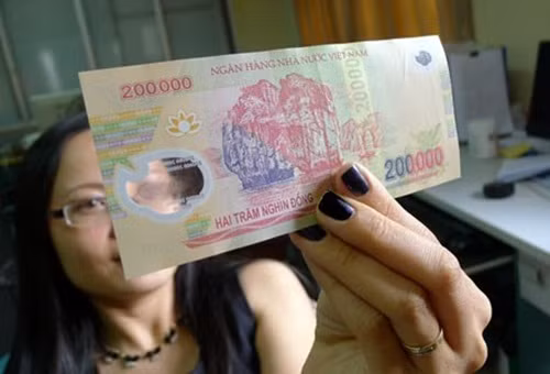 Trong khi đó ở tiền giả, cụm số mệnh giá dập nổi trên cửa sổ lớn không tinh xảo như tiền thật, trong cửa sổ nhỏ không có hình ẩn.
