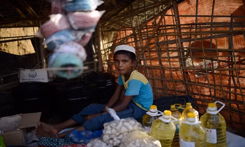 Một bé trai Rohingya ngồi bán hàng trong khu trại Balukhali.