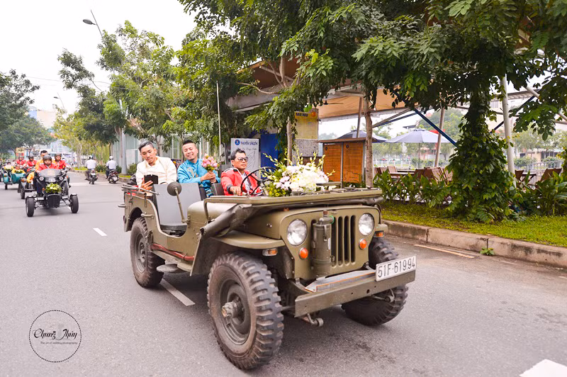 Chiếc xe jeep chở chú rể Wang Trần dẫn đầu dàn motor chở các phù rể với trang phục rực rỡ, nổi bật trên đường phố Sài Gòn.