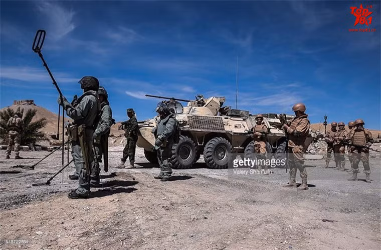 Các binh sĩ công binh Nga hoạt động tại Palmyra dưới sự bảo vệ nghiêm ngặt từ đồng đội. Nguồn ảnh: Sina
