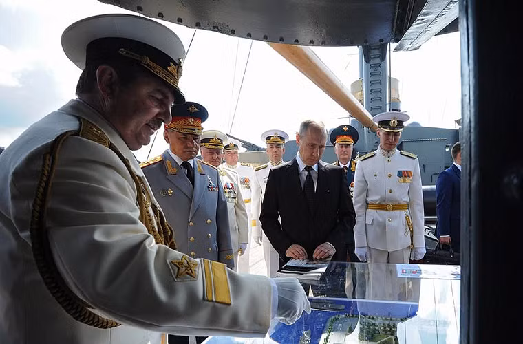 Hình ảnh Tổng thống Nga Putin được sĩ quan trên tàu Rạng Đông giới thiệu một số mô hình được trưng bày trên tuần dương hạm này.