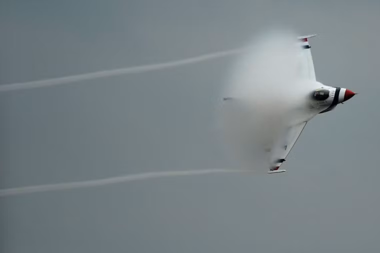 Tiêm kích F-16 thuộc đội bay biểu diễn Thunderbirds của Không quân Mỹ vượt tường âm thanh trong tư thế bay nghiêng.