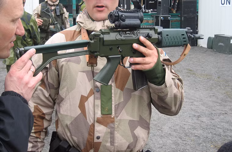 Trong ảnh là một khẩu Bofors Ak 5D được trang bị kính ngắm Aimpoint AB, với tay cầm và ốp tay phía trước được làm bằng vật liệu tổng hợp nhằm giảm trọng lượng của súng.